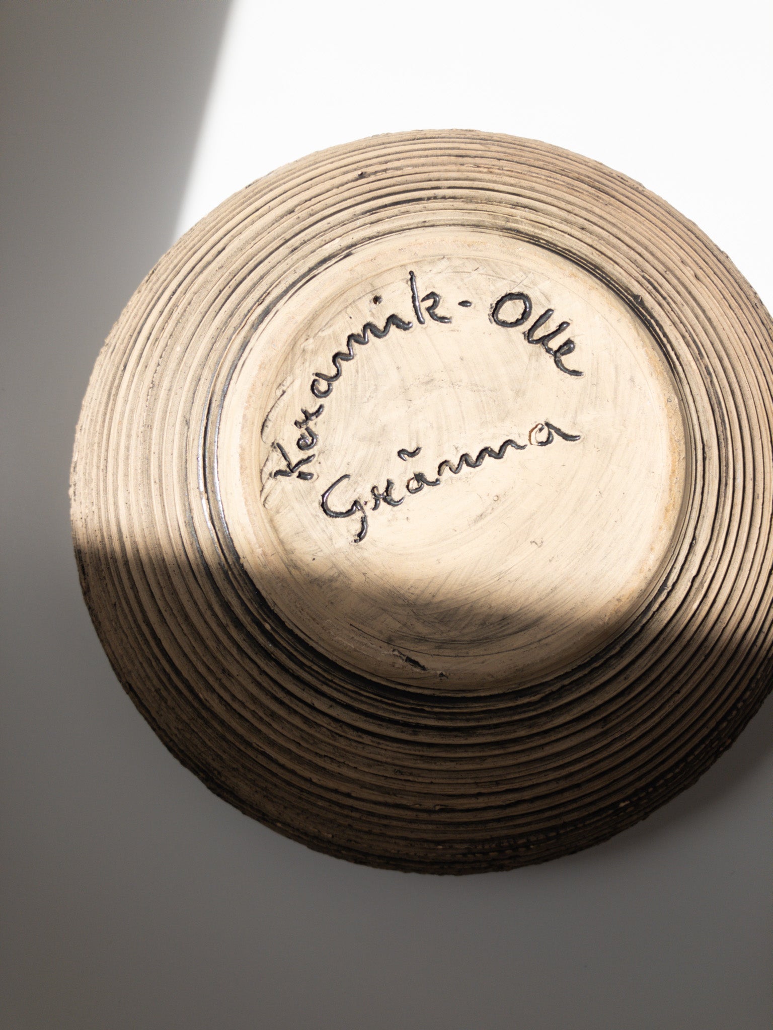 底部分を写した写真、手書きのサインが彫られている